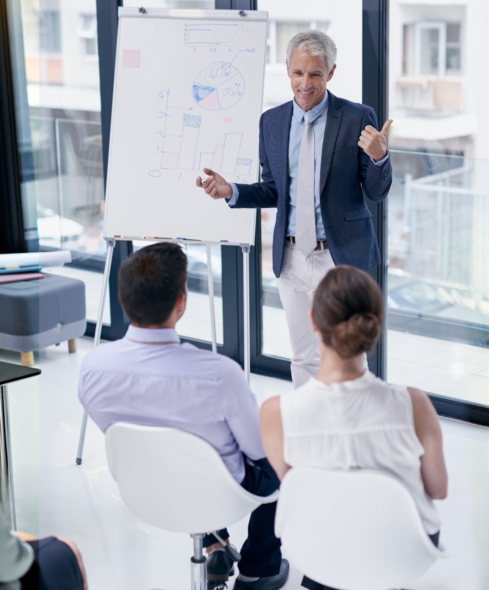 discussing plans business shot businessman giving presentation colleagues office discussing plans business shot businessman giving presentation colleagues office