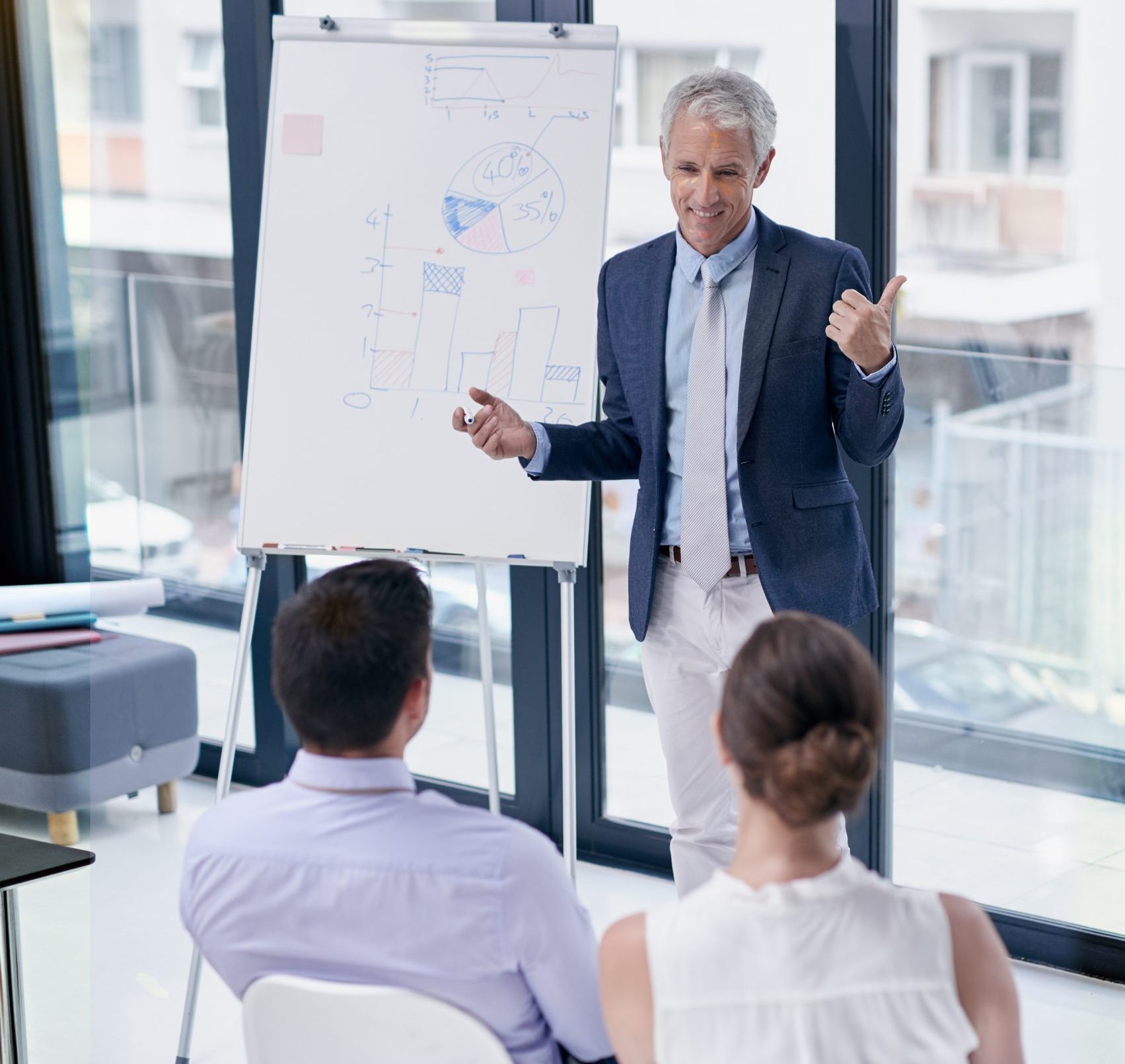 discussing plans business shot businessman giving presentation colleagues office discussing plans business shot businessman giving presentation colleagues office
